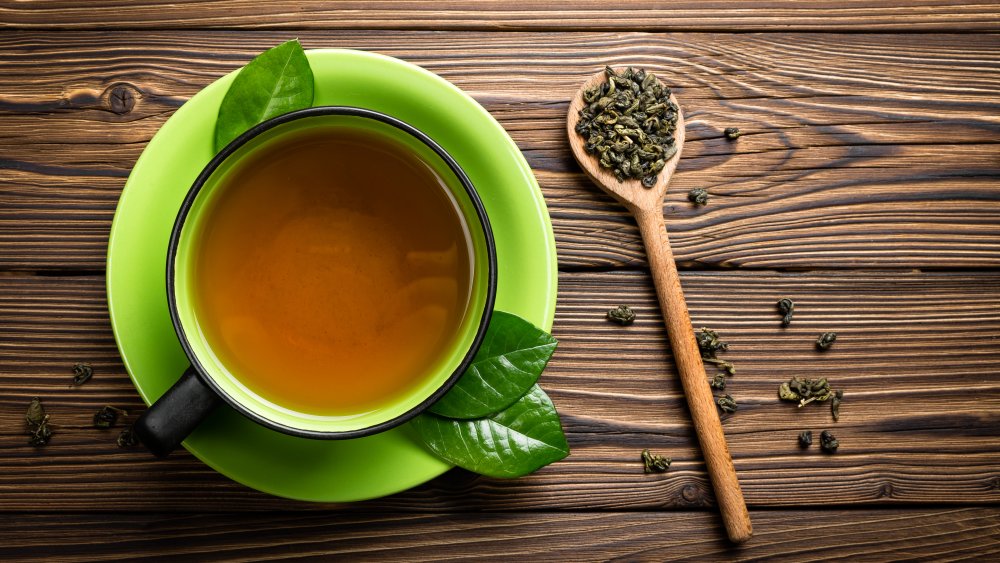 Kendall Jenner typical food: A cup of tea with herbs on a wooden table