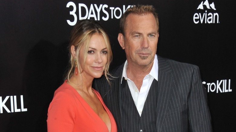 Christine Baumgartner and Kevin Costner smiling on the red carpet