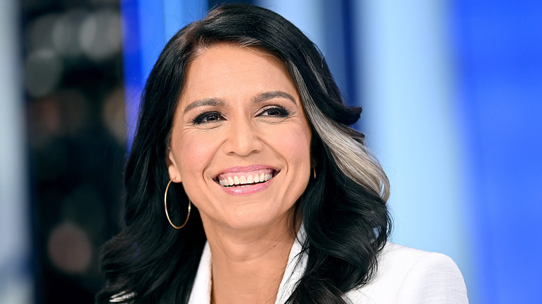 Tulsi Gabbard smiling in a white blazer