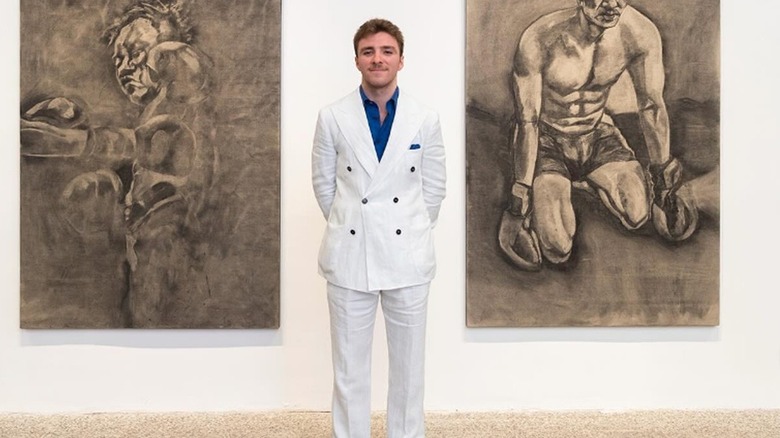 Rocco Ritchie standing in between drawings