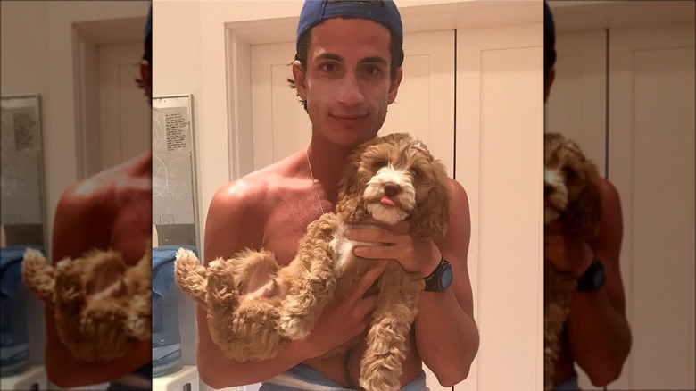 Jack Schlossberg holding his family's dog