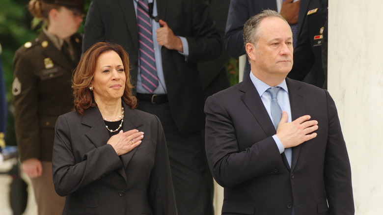 Kamala Harris and Doug Emhoff stand as they do the "hand-over-heart" salute