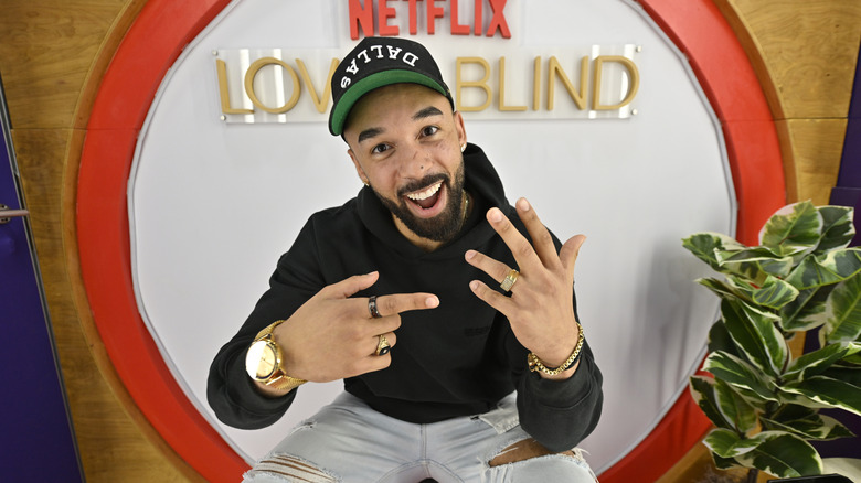 Bartise Bowden pointing to his wedding ring in front of Netflix and "Love Is Blind" sign