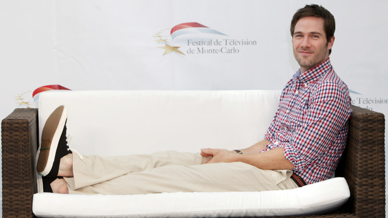 Luke MacFarlane posing on couch