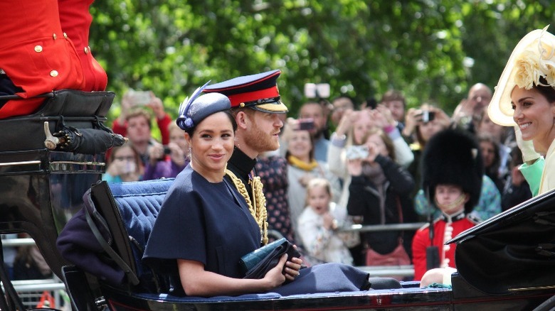 Meghan Markle, Prince Harry, and Kate Middleton in a carriage