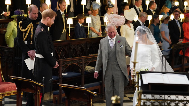 King Charles walking Meghan Markle down the aisle to Prince Harry at their wedding