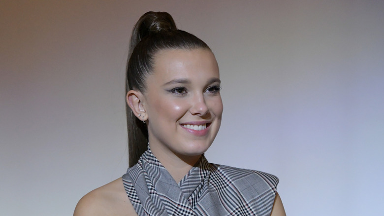 Millie Bobby Brown sits onstage at an event