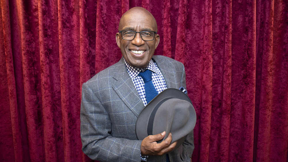 Al Roker in a suit in front of a velvet curtain