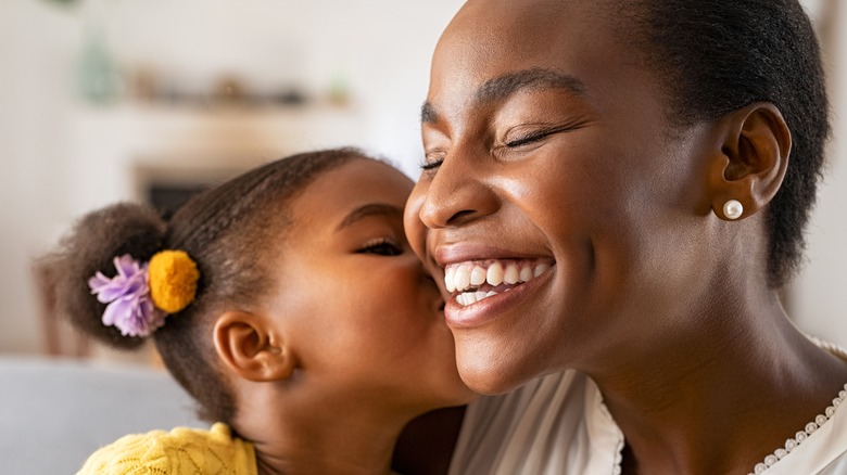 daughter kissing her mom on the cheek