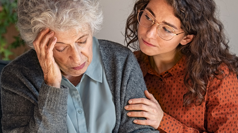 Woman with glasses comforting old woman 