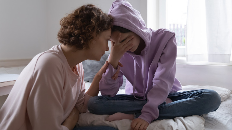 Parent comforts crying teen