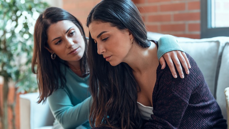 woman consoling friend on sofa