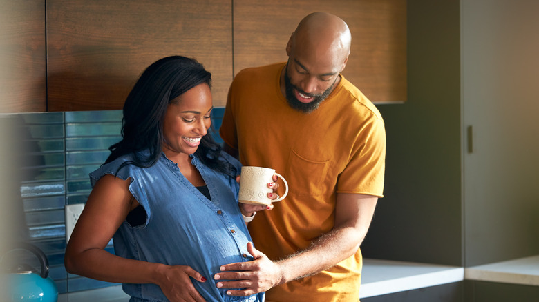 pregnant woman drinking coffee with husband