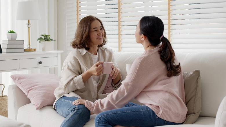 two women smiling with mugs