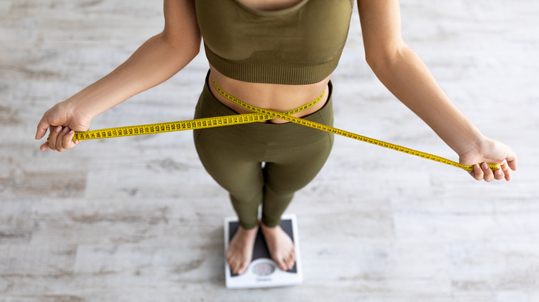 woman on scale measuring waist