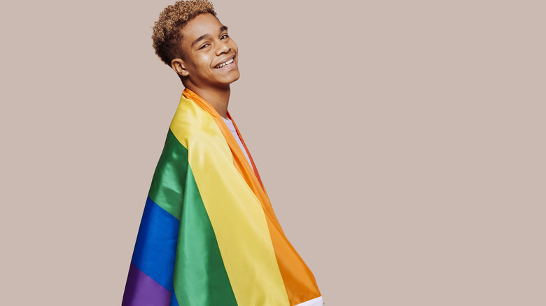 LGBTQIA+ youth wrapped in flag