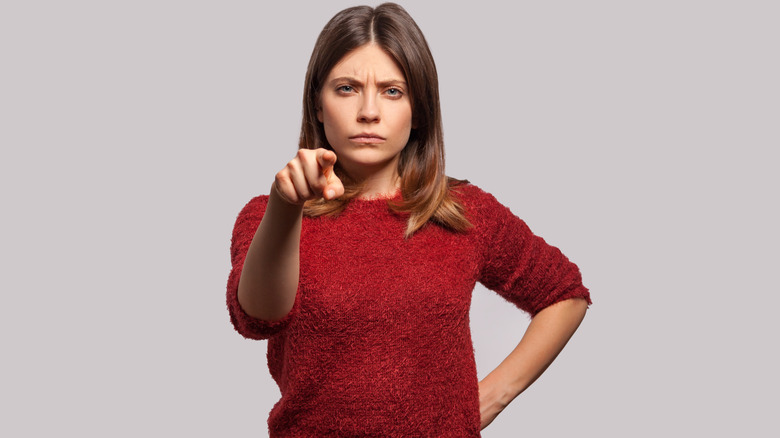 Woman pointing finger frowning