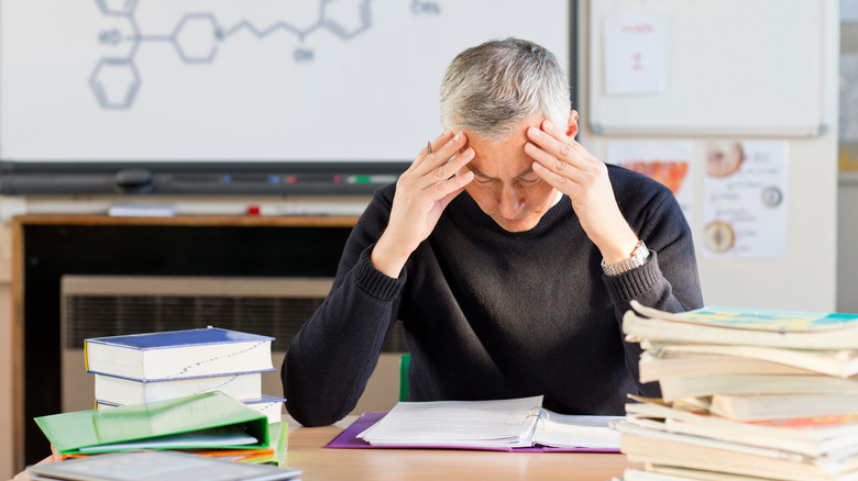 Stressed teacher grading homework