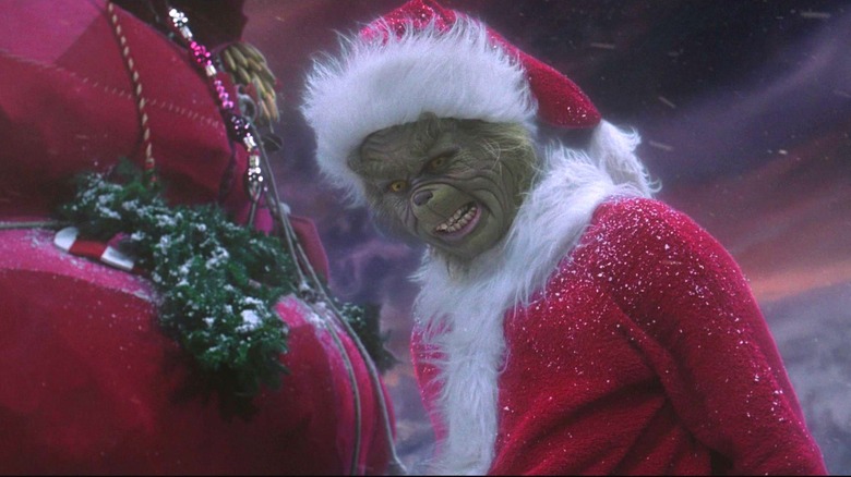 Jim Carrey scowling as the Grinch in Santa suit