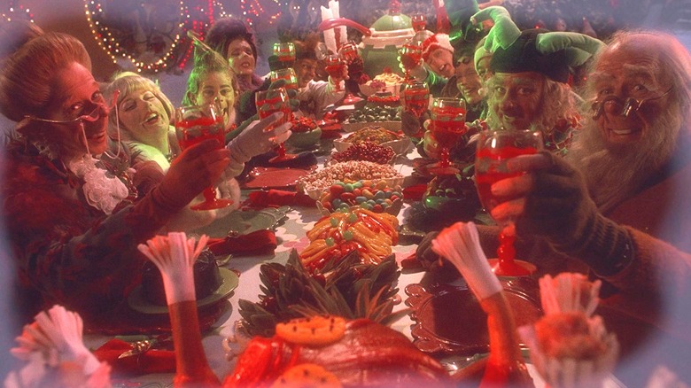 A still image of the Whos raising glasses at the dinner table