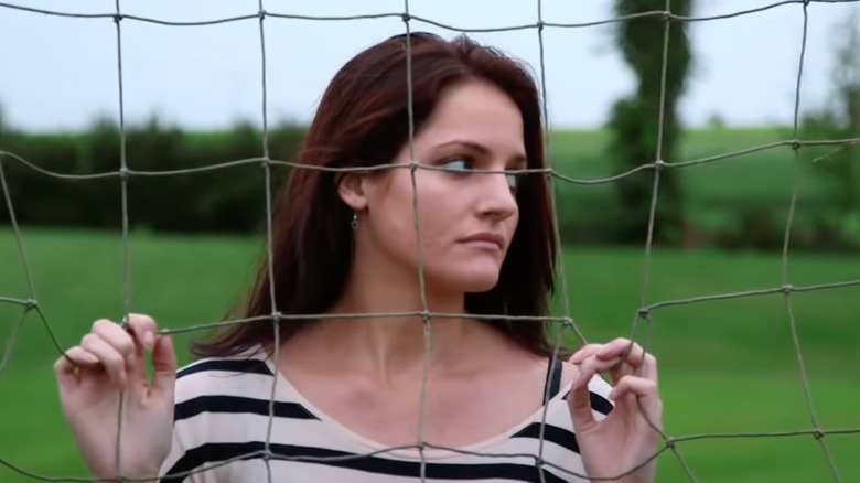Kate Stoltz holding a fence on "Return to Amish"