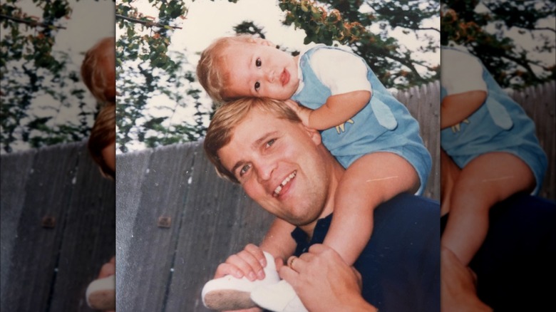 Retro photo of Aaron O'Connell sitting on his father's shoulders as a toddler