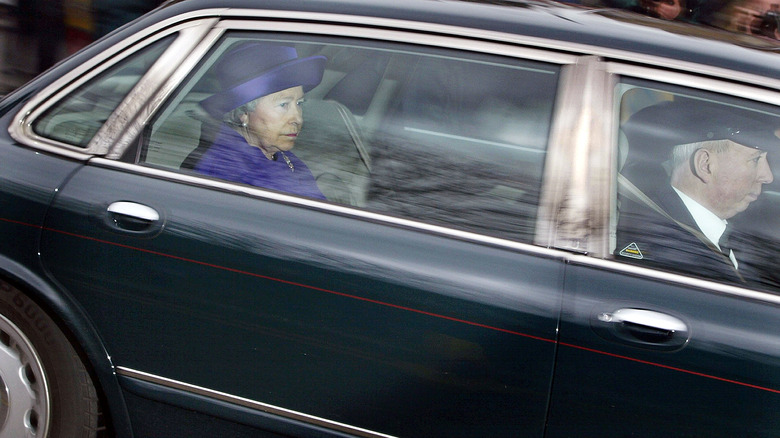 Queen Elizabeth wearing purple in a car