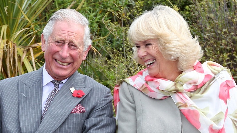 Charles and Camilla laughing outdoors