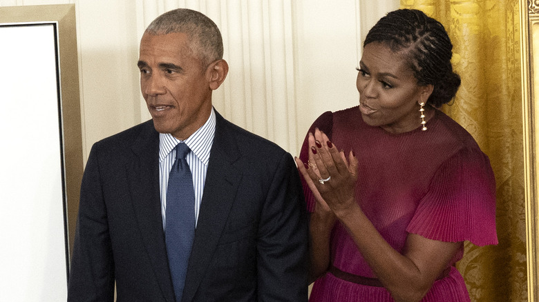 Barack and Michelle Obama smiling and clapping 