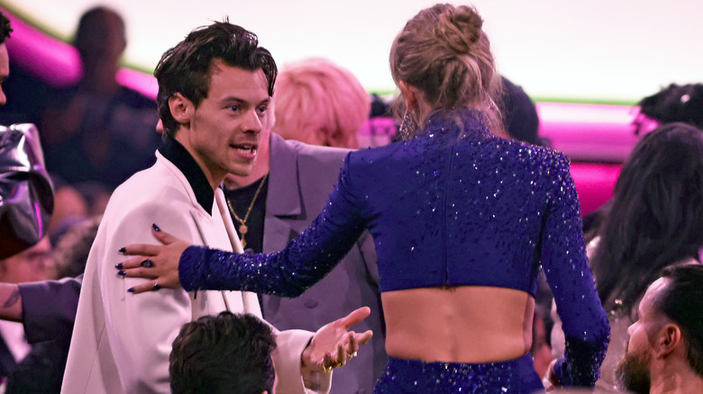 Taylor Swift and Harry Styles talking from behind