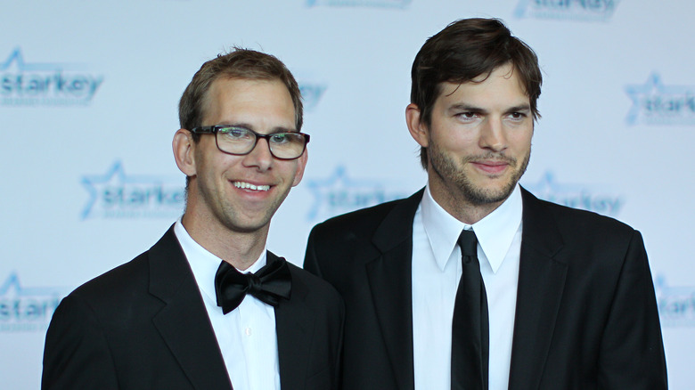 Ashton Kutcher posing with his twin brother Michael