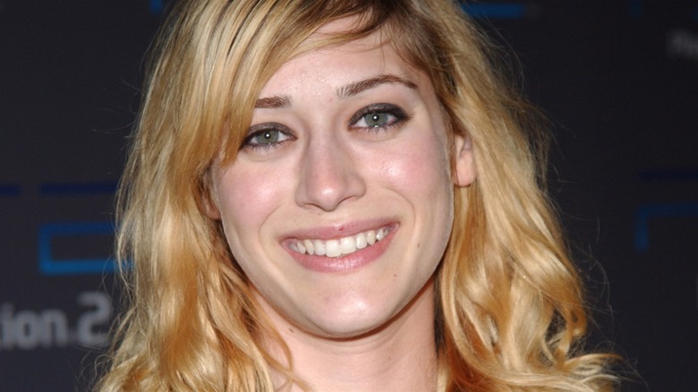 Smiling blonde Lizzy Caplan