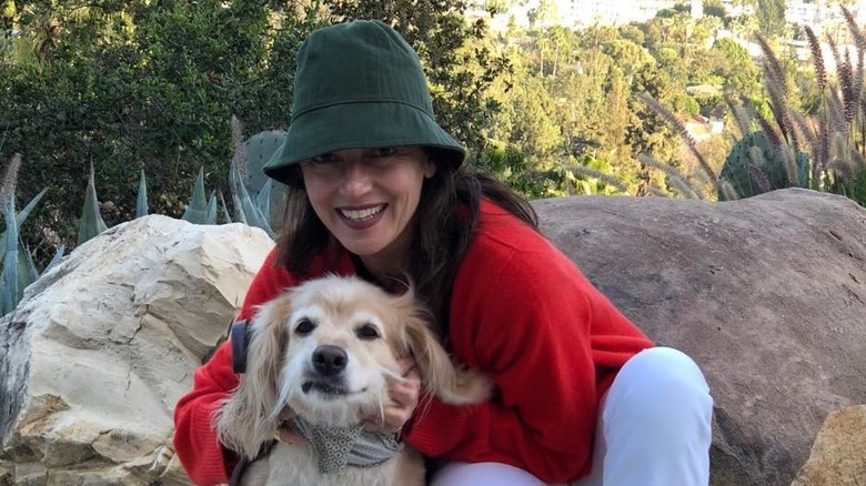 Mia Sara cuddles a dog