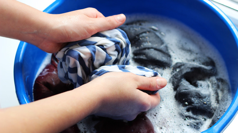 Hands washing fabric in a basin 