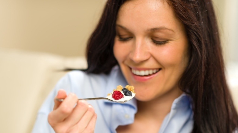 woman eating yogurt with granola