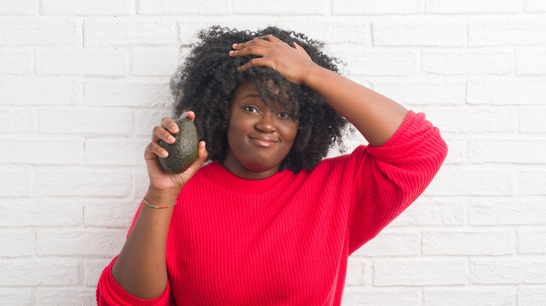 Stressed-out woman holding an avocado