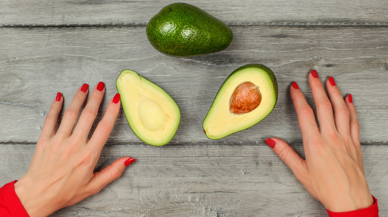 a woman's hands and avocados