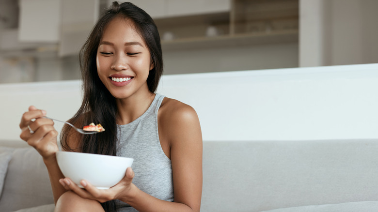 woman smiling while eating oatmeal