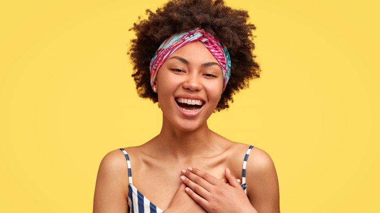 A woman smiling with her hands on her chest