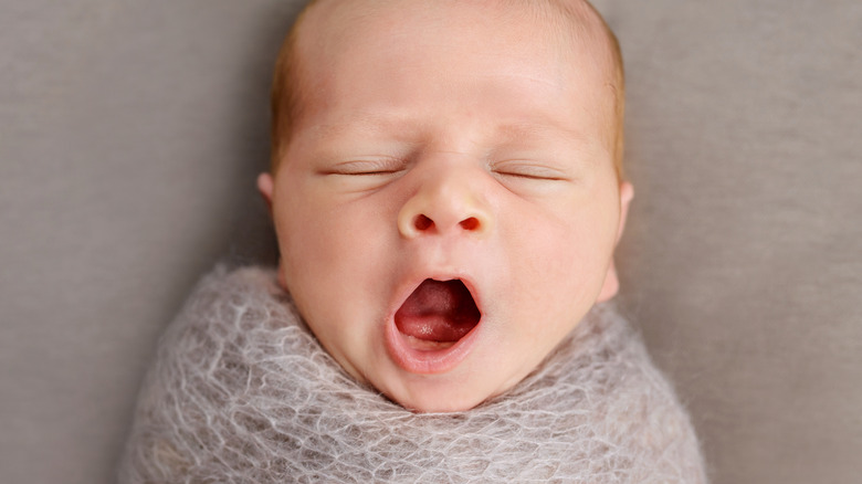 Newborn baby yawning in a cute photoshoot