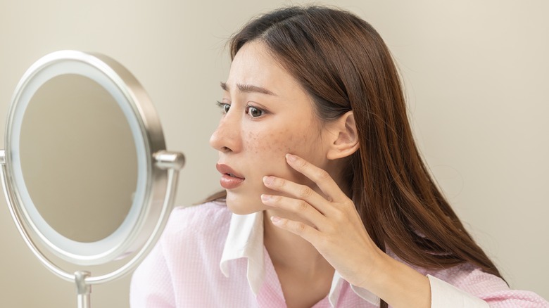 A woman assessing her skin