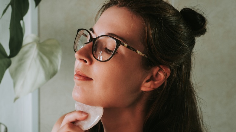 woman using gua sha 