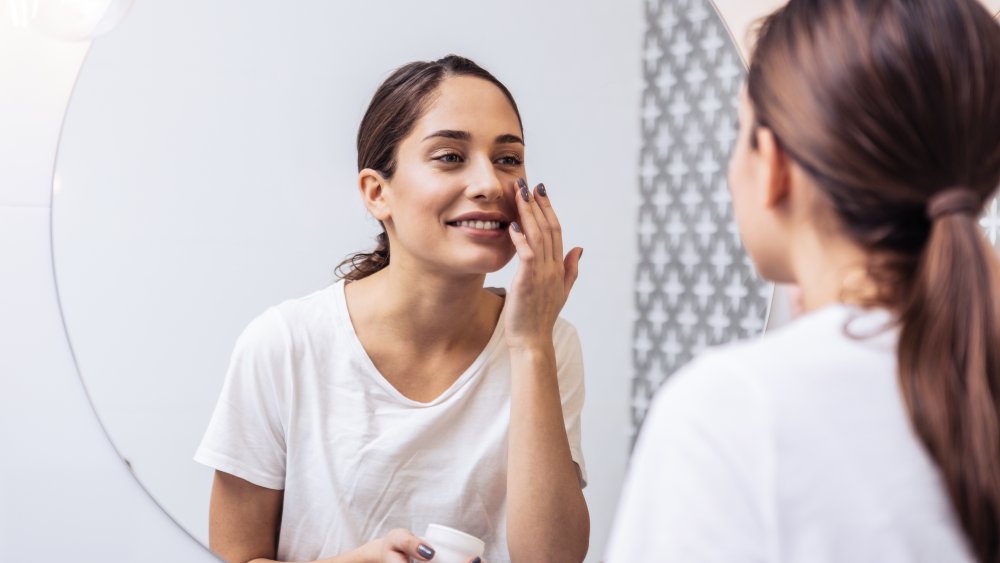 woman with ponytail looking at clear skin