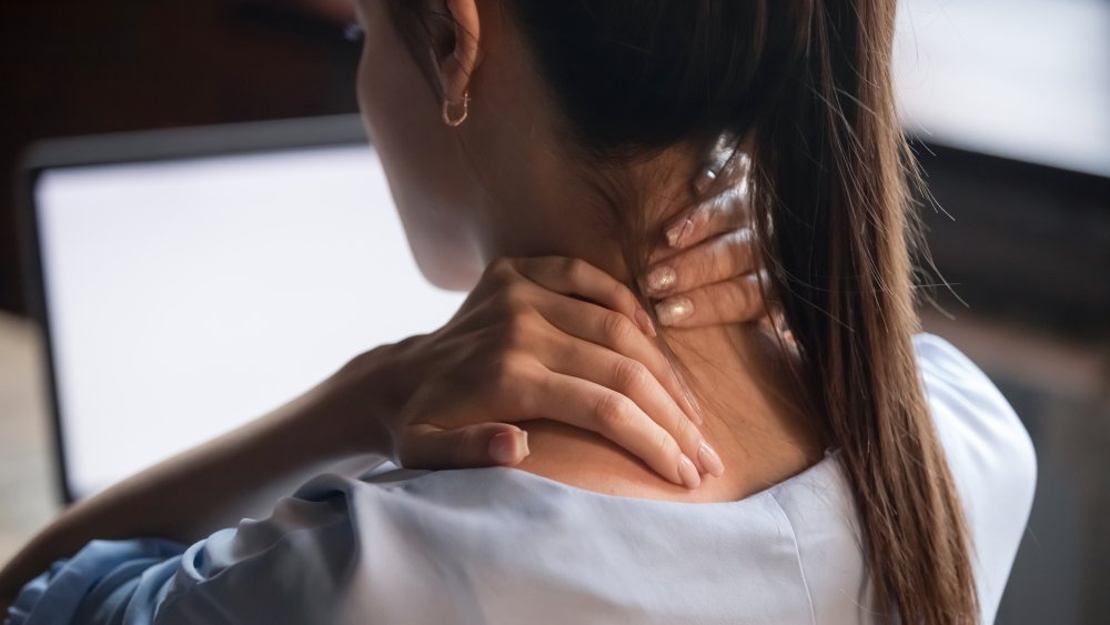 woman with ponytail experiencing neck pain
