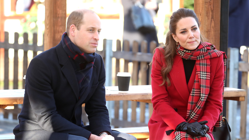 Prince William and Kate Middleton sitting outdoors