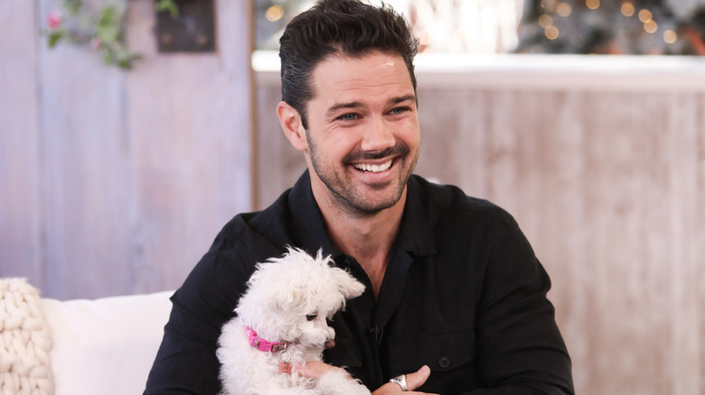 Ryan Paevey plays with dog