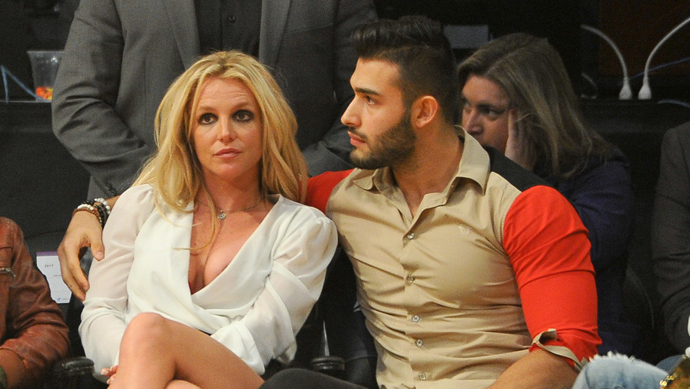 Sam Asghari with his arm around Britney Spears 