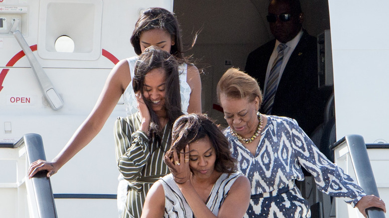 Sasha, Malia, Michelle Obama, and Marian Robinson getting off a plane