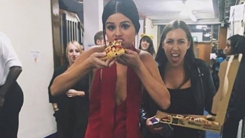 Selena Gomez eating pizza after a show