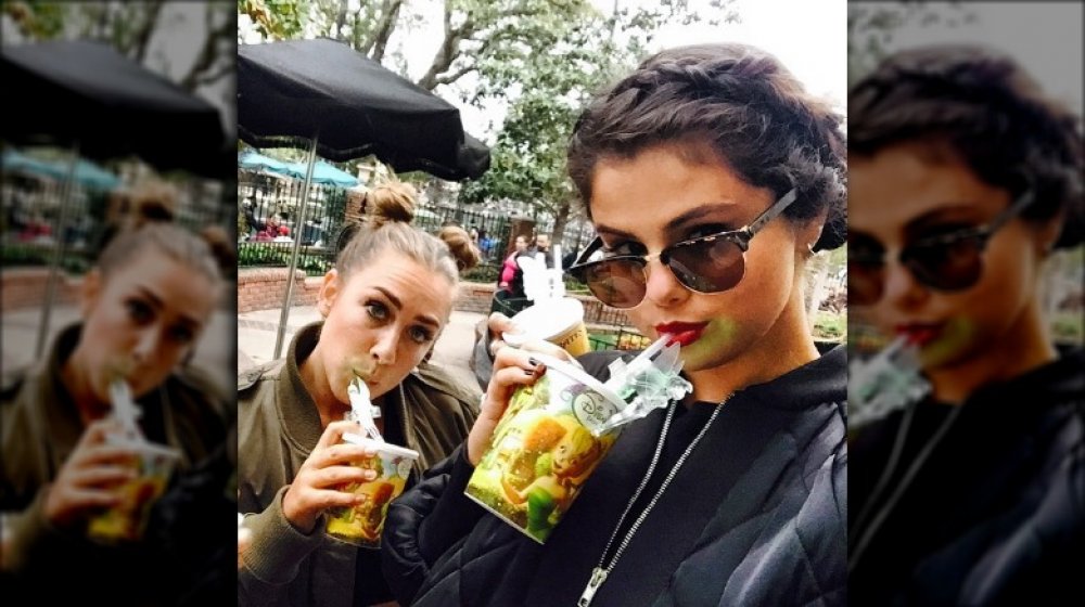 Selena Gomez sipping on a beverage at Disney with a friend